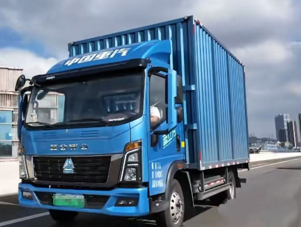 Chinese used cargo trucks operating on African roads — HOWO box truck delivering goods in Nigeria