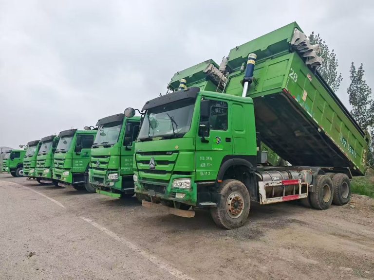 Used Chinese mining dump trucks HOWO and Shacman parked at truck yard in China ready for export to Africa