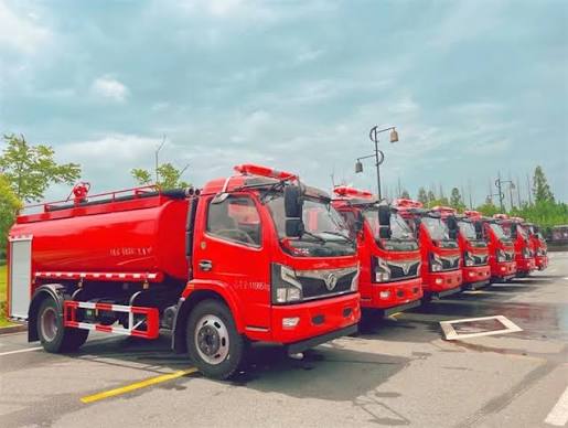 Used water sprinkler truck from China for Africa export. White tanker truck with spray nozzles and large cylindrical tank at Chinese depot.