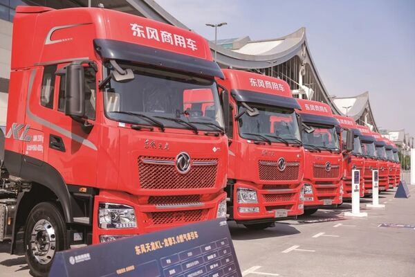 Rows of used Dongfeng trucks at an export yard in China, showing Tianlong and KL models ready for Africa