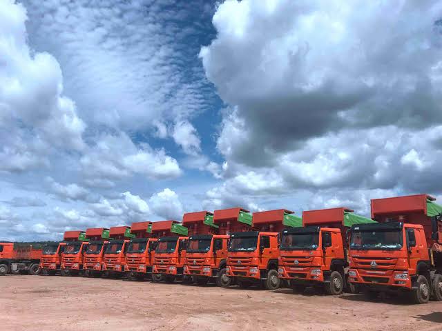 Red HOWO dump trucks parked on African red laterite soil representing Chinese truck durability and lifespan in Africa
